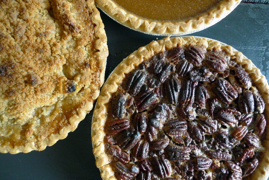 Bourbon Chocolate Pecan Pie, Dutch Apple Pie, and Pumpkin Pie are all shown in this photo.
