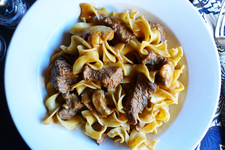 Bowl with sliced beef, egg noodles, mushrooms in a stroganoff sauce.