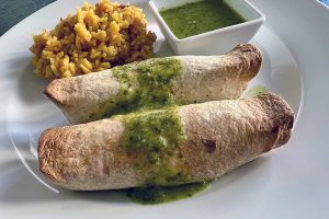 Chicken Enchiladas Verdes includes two chicken enchiladas topped with verde sauce, shown with rice.