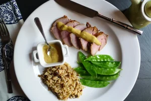 Asian Pork Tenderloin shown plated with sides dishes.