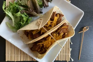 Beef Barbacoa Tacos plated with salad greens.