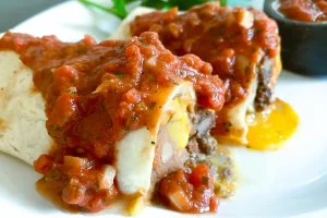 Beef, Bean, and Cheese Burrito cut in half to show filling, topped with salsa.