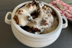 Chocolate Cherry Bread Pudding with Vanilla Icing in a bowl.