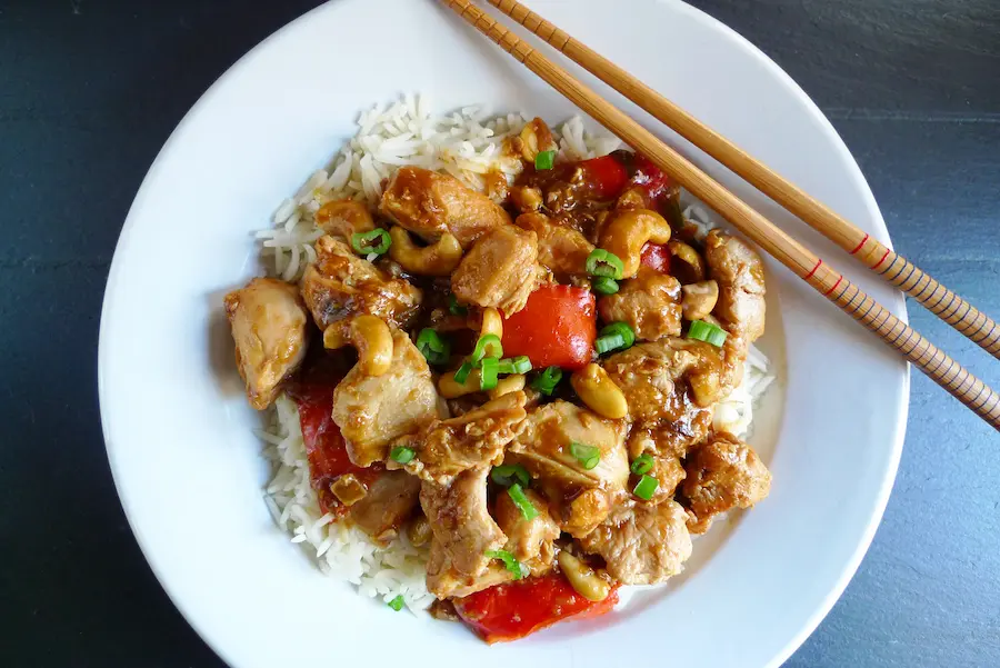 Cashew Chicken Stir Fry over Rice in a bowl with chopsticks.