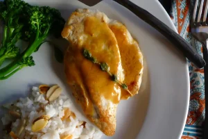 Chicken Cutlets with Citrus Beurre Blanc shown plated with side dishes.