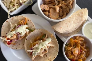 Chicken Fajitas shown with slaw and creamy cilantro sauce.