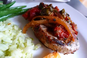 Pork Chops with Roasted Red Pepper Bruschetta shown plated with side dishes.