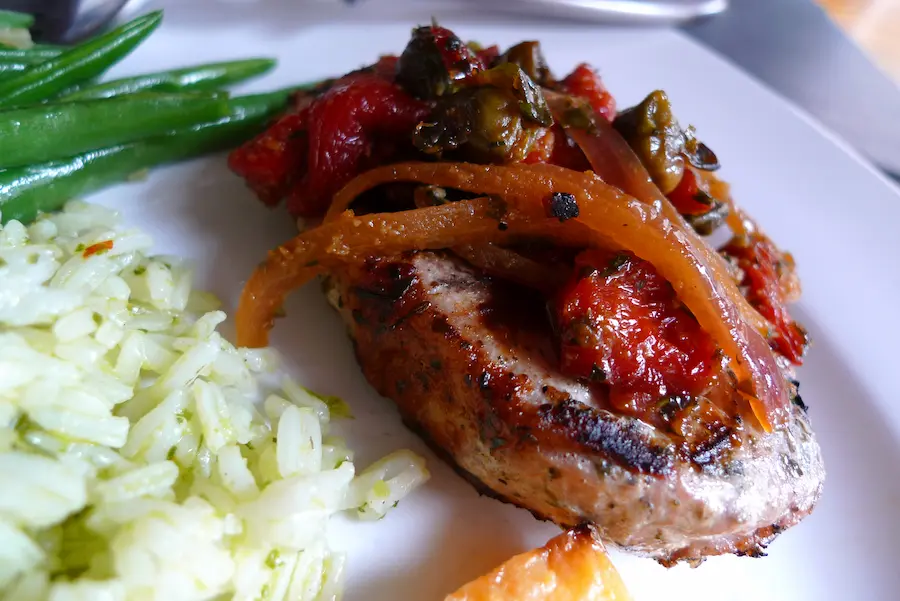 Pork Chops with Roasted Red Pepper Bruschetta shown plated with side dishes.