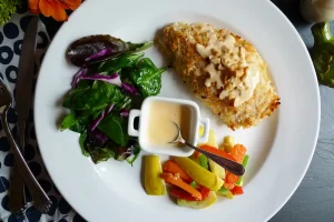 Coconut Chicken with Cashew Red Curry Sauce shown plated with various side dishes.
