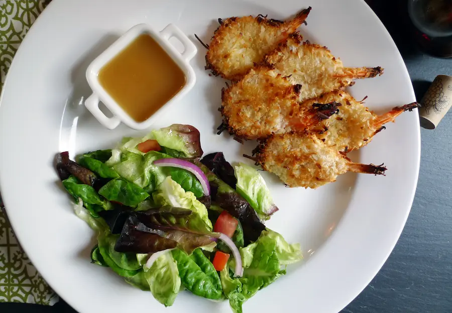 Coconut Shrimp with Orange Sauce shown served with a salad.