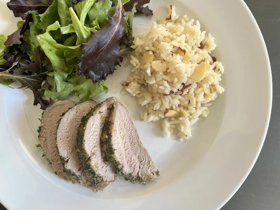 Dijon Herb Pork Tenderloin and Almond Rice Pilaf, shown plated with a side salad.