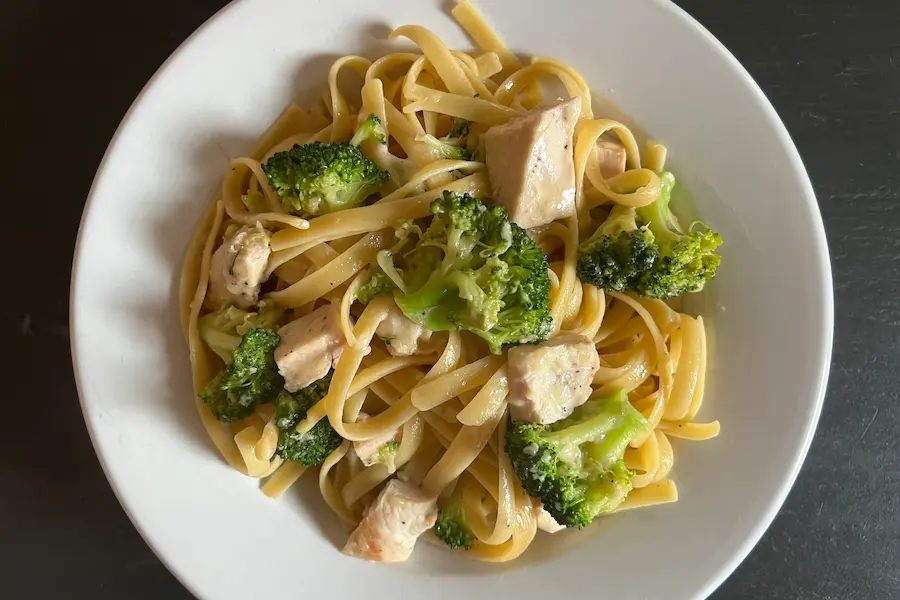 Fettuccine Chicken Alfredo with Broccoli in a white bowl.