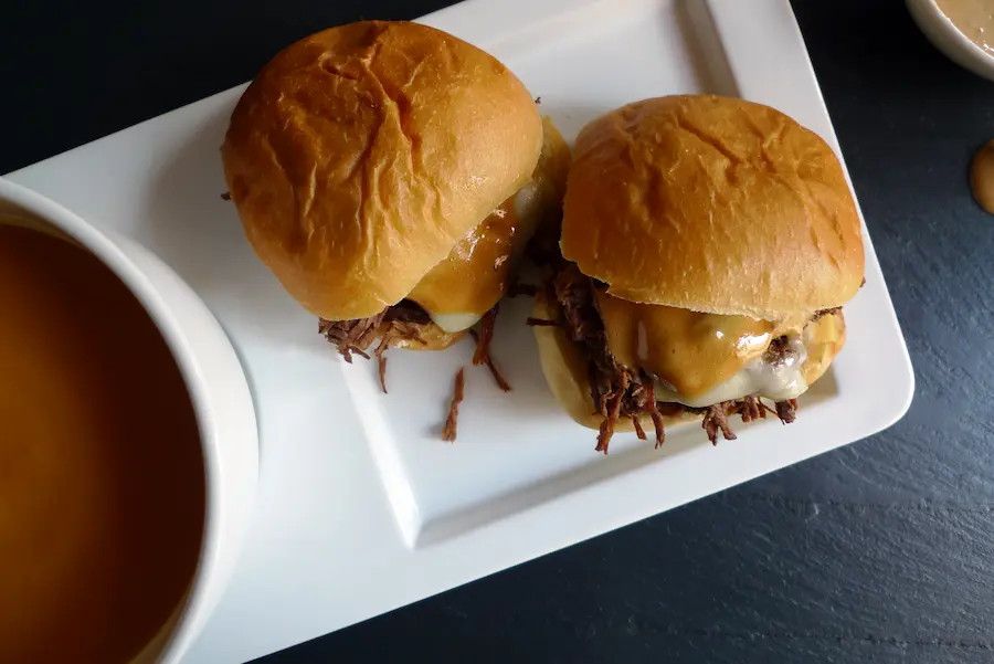 French Onion Beef Sliders shown plated with a bowl of soup.