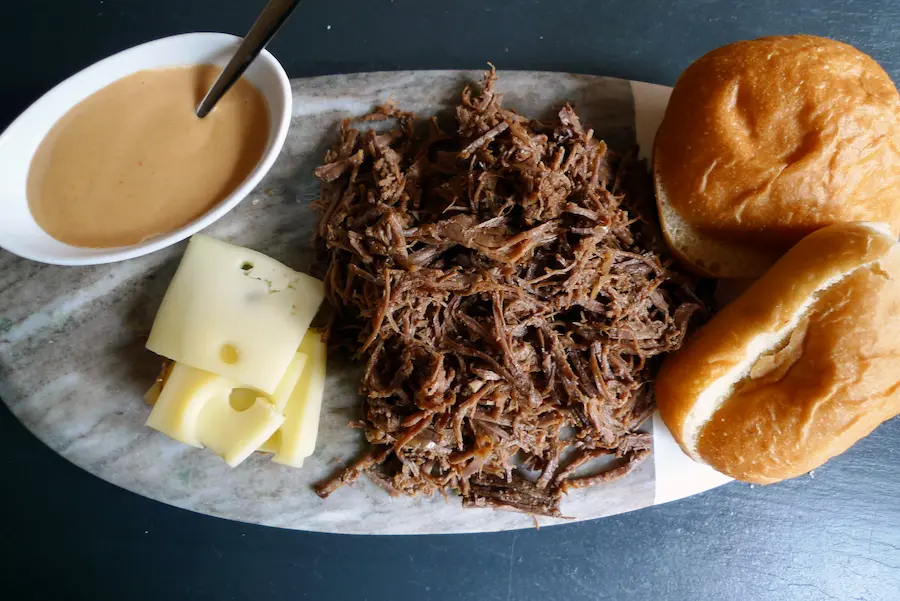 Shows individual ingredients for the French Onion Beef Sliders - shredded beef, slider rolls, cheese, and sauce.