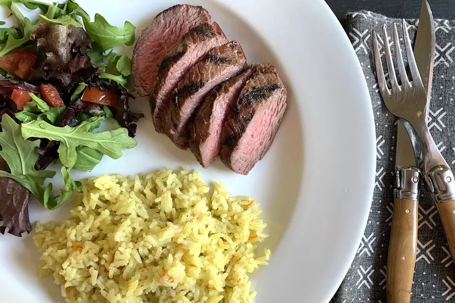 Ginger Sesame Beef Filet with Asian Rice shown plated with a salad.