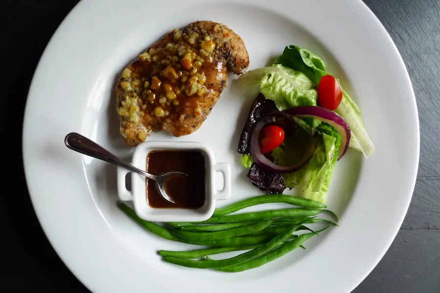 Herbed Balsamic Bleu Chicken shown plated with side dishes.