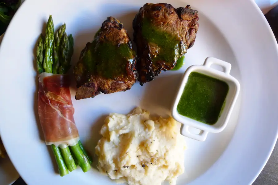 Lamb Chops with Mint Chimichurri shown plated with side dishes.