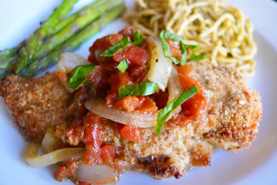 Close up view of Parmesan Pesto Chicken with Bruschetta.