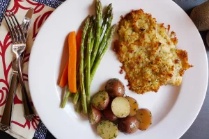 Parmesan Crusted Tilapia served plated with veggies.