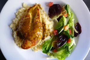 Piri Piri Chicken over Couscous, shown plated with a side salad.