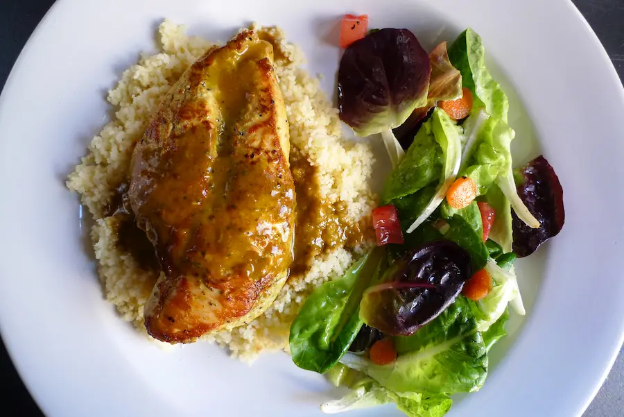Piri Piri Chicken over Couscous, shown plated with a side salad.