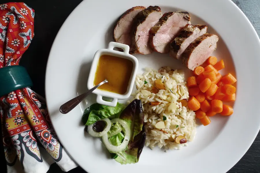 Pork Tenderloin with Apricot Sauce shown served with side dishes and salad.