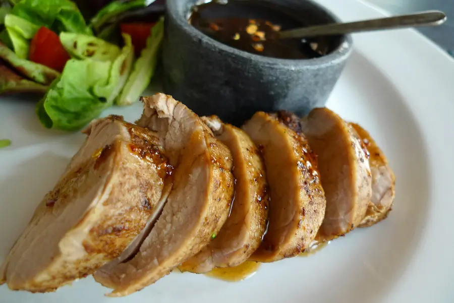 Pork Tenderloin with Spicy Maple Mop shown plated with salad.