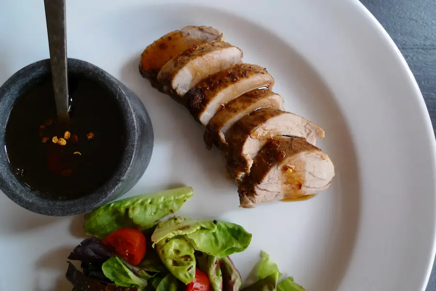 Pork Tenderloin with Spicy Maple Mop shown plated with salad.