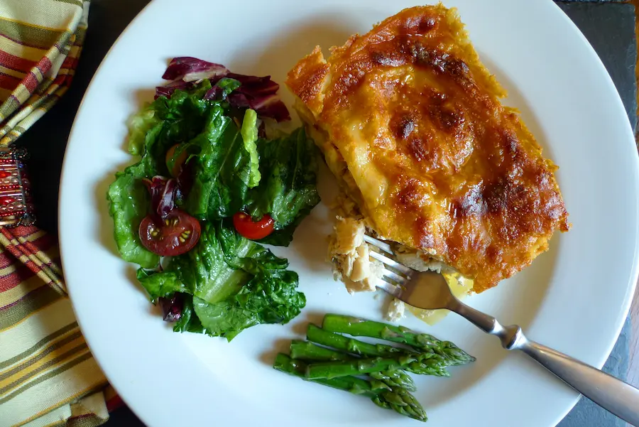 Pumpkin Chicken Alfreodo Lasagna shown plated with salad.