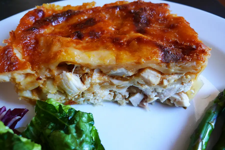 Pumpkin Chicken Alfredo Lasagna shown plated with salad.