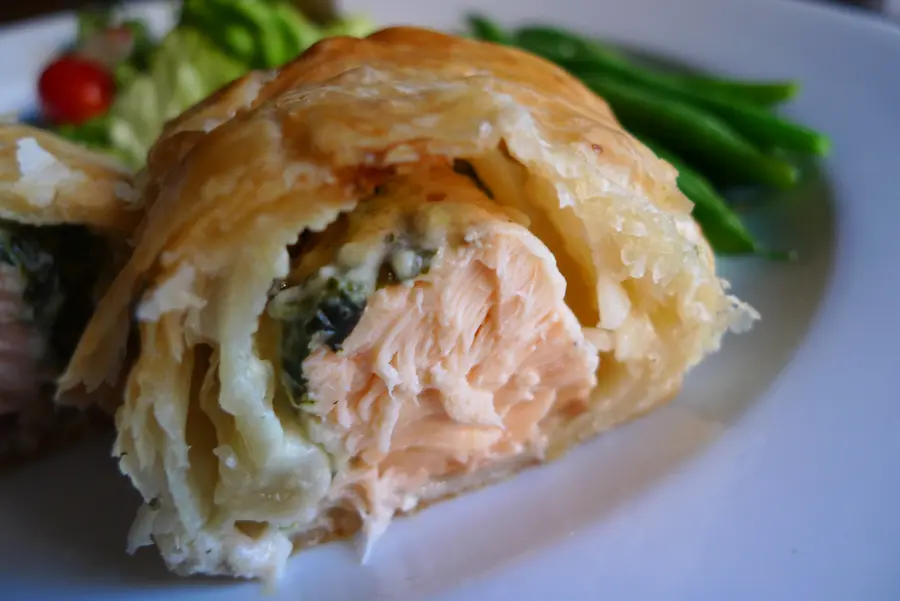 Salmon Florentine Pastry shown sliced to show salmon florentine filling.