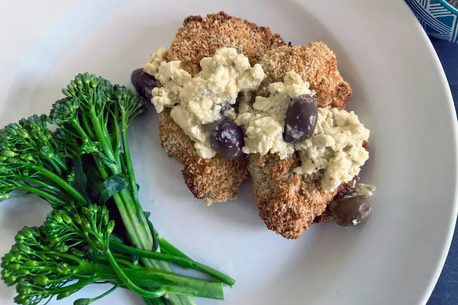 Santorini Style Chicken Cutlets shown plated with a vegetable side.