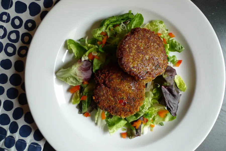 Shrimp Cakes served plated over salad greens.