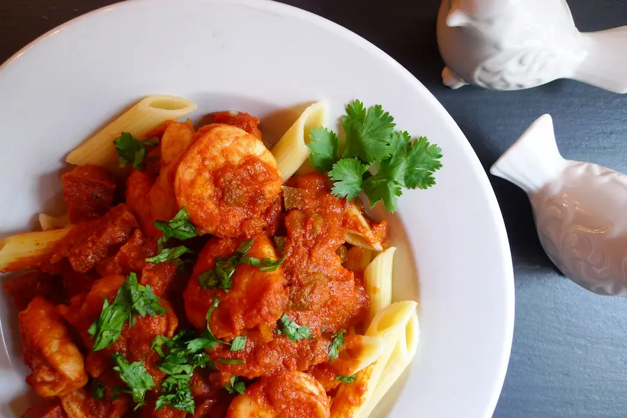 Close up of Spanish Shrimp over Penne Pasta. Shown garnished with fresh parsley.