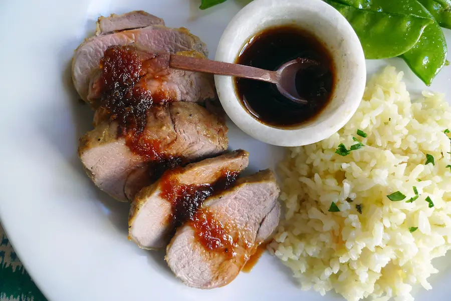 Teriyaki Pork Tenderloin with Pineapple Rice shown served with a vegetable side dish.