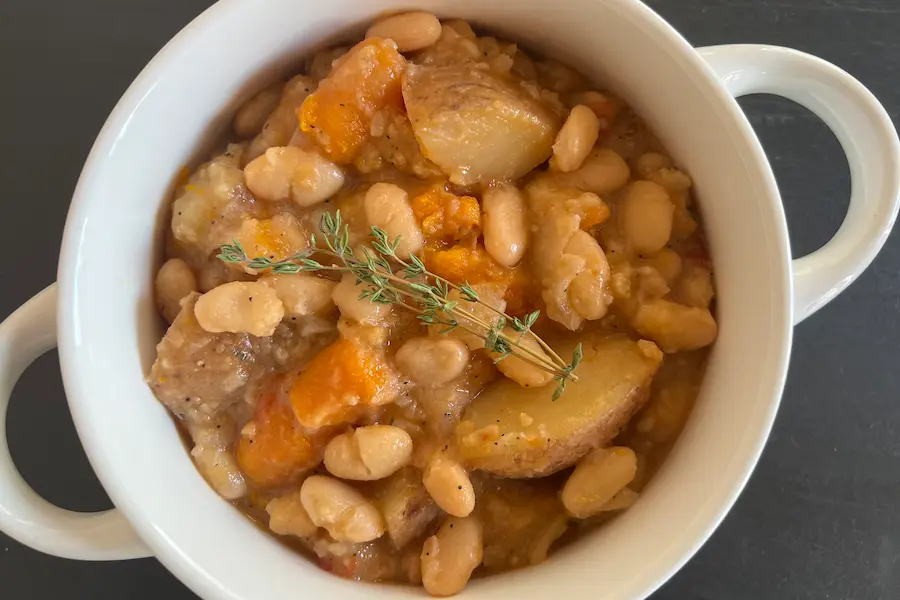 A vegan french bean cassoulet with white beans, potato, carrots, and fresh herbs.